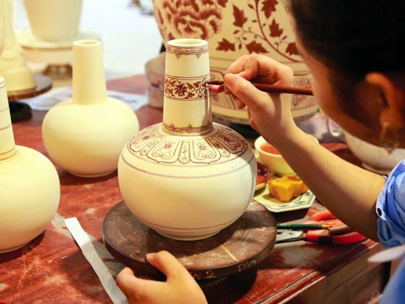 Decorazione dipinta a mano su un manufatto in ceramica tradizionale del villaggio di Chu Dau